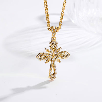 A gold cross pendant necklace encrusted with small clear stones, hanging from a gold chain on a white background.