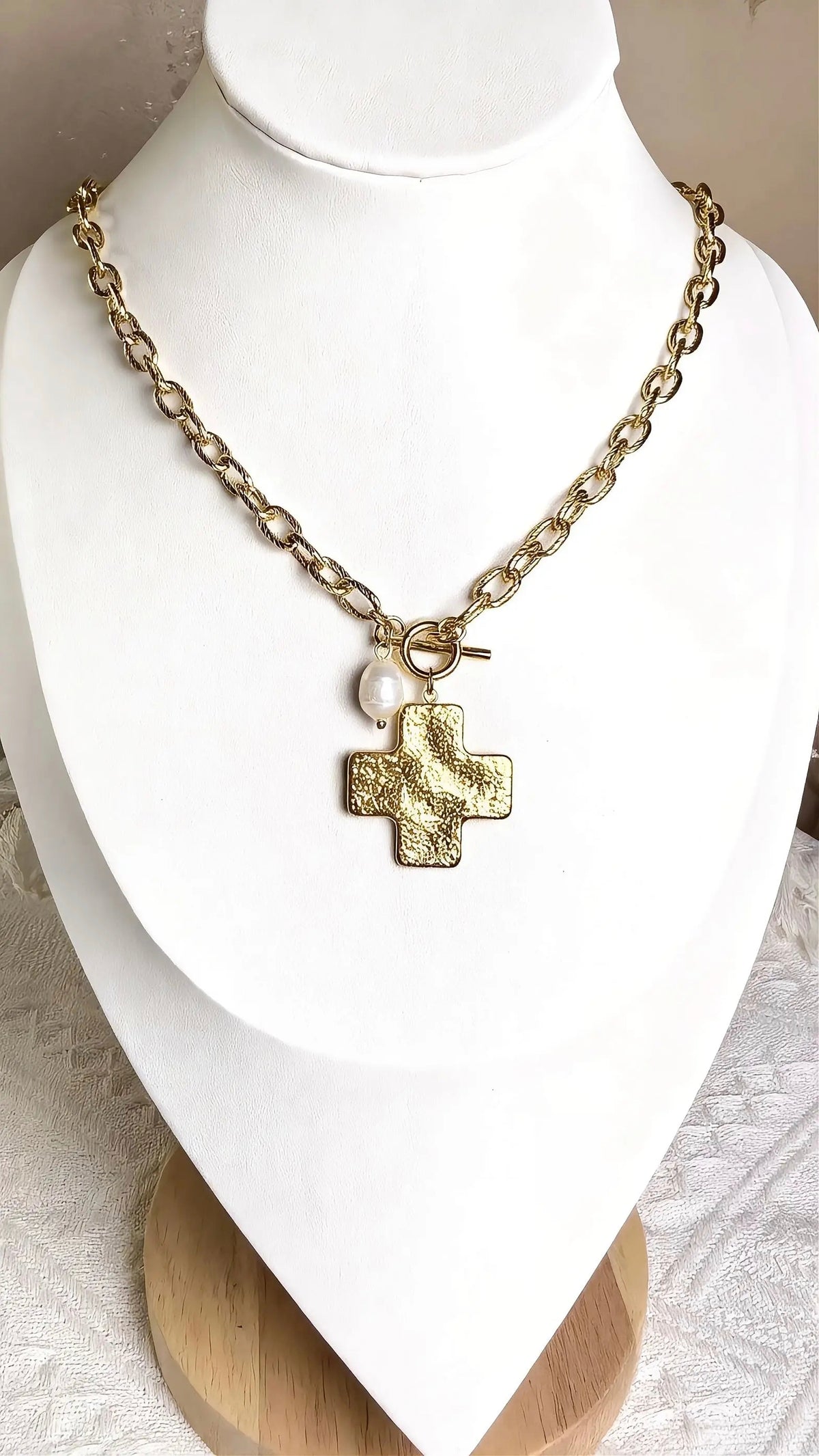 Pearl Gold Cross Necklace on white jewelry display stand