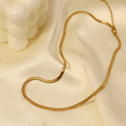Gold Herringbone Chain Necklace draped on white fabric — elegant everyday necklace