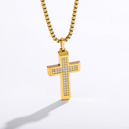 A gold cross pendant necklace with a channel-set row of clear cubic zirconia stones on the front, suspended from a gold box chain against a white background.