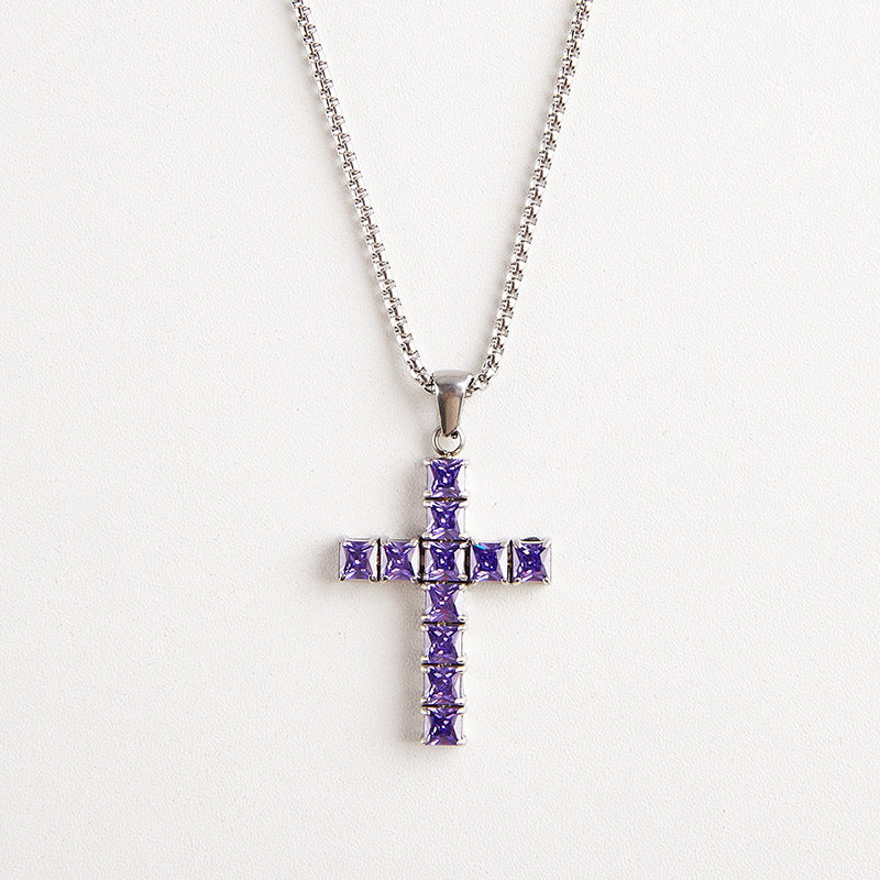 A silver cross pendant necklace adorned with square-cut purple gemstones, suspended from a silver ball chain against a plain white background.